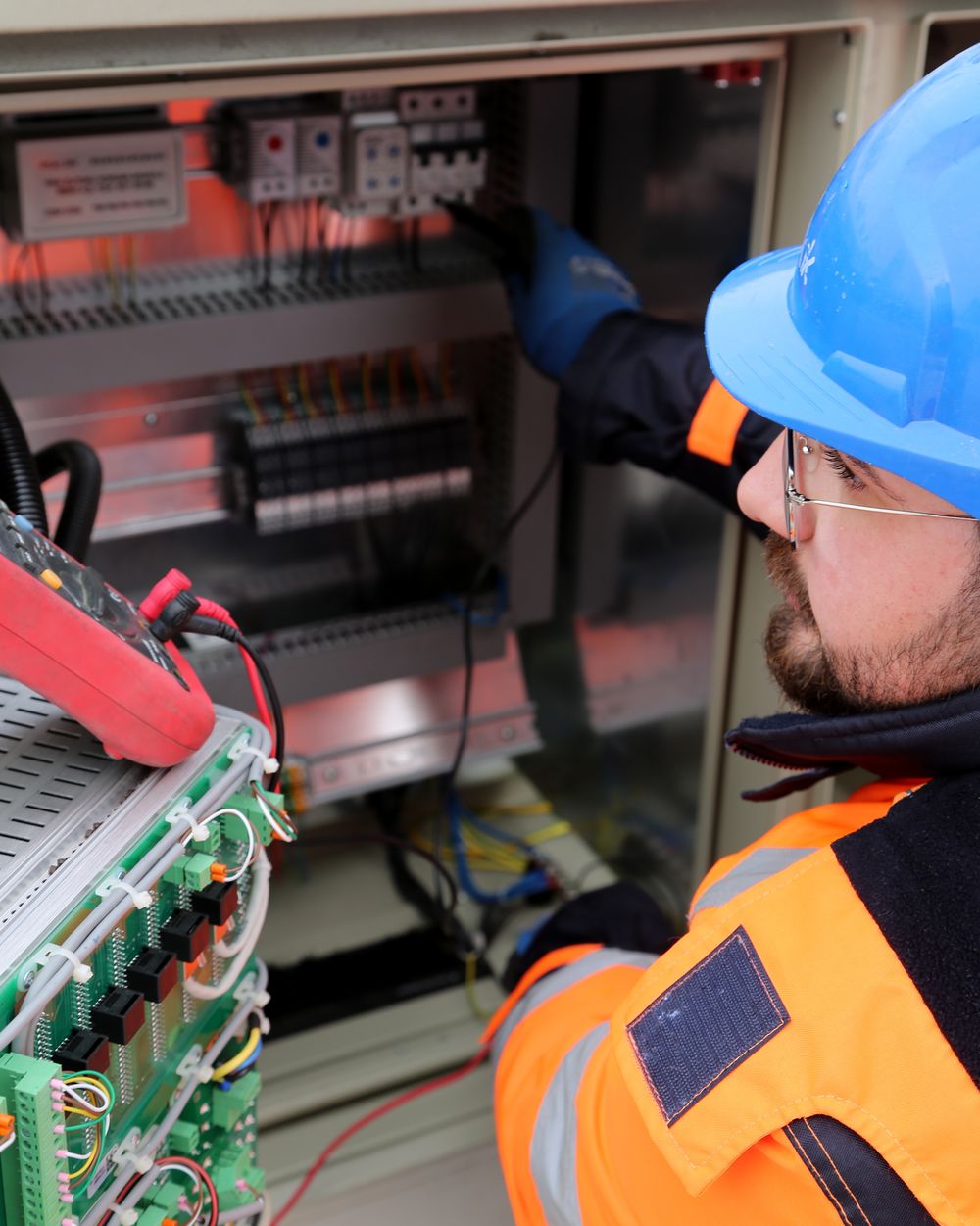 Electrician wiring a commercial control panel with breakers and contactors